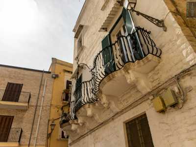 Il particolare ballatoio � sorretto da massicci mensoloni al secondo dei tre livelli che compongono la bianca facciata